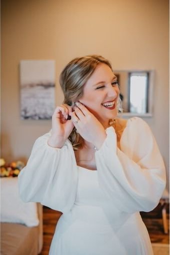 Getting Ready: die Braut legt Ohrringe an