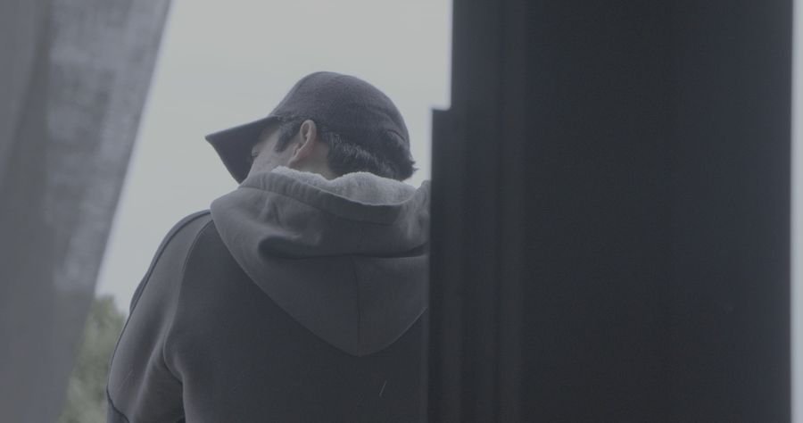Szenenbild aus einem Musikvideo: Mann mit Kapuze